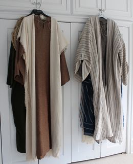 three sweaters hanging on the wall next to each other in front of white cabinets