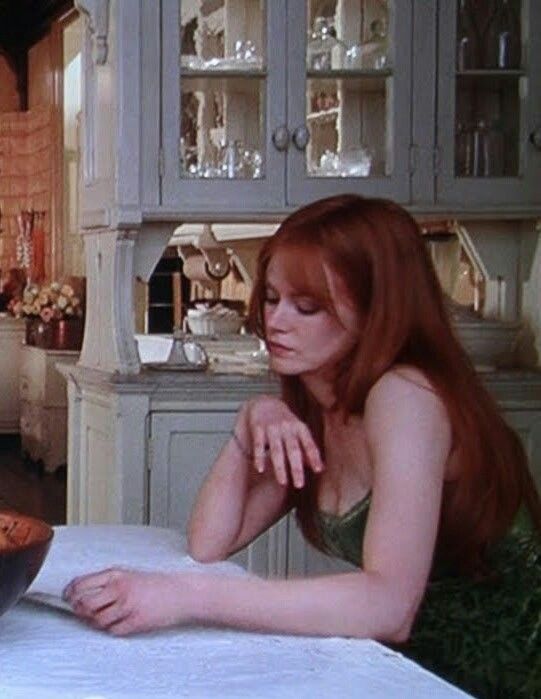 a woman sitting at a table in front of a pot