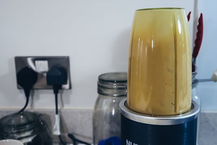 a blender sitting on top of a counter next to jars