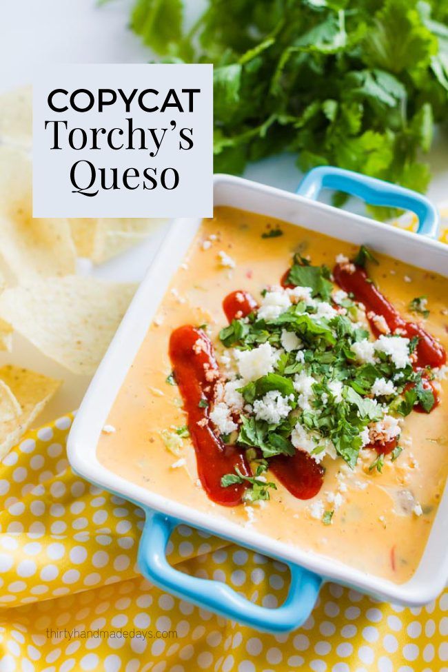 a bowl of soup with tortilla chips and cilantro on the side