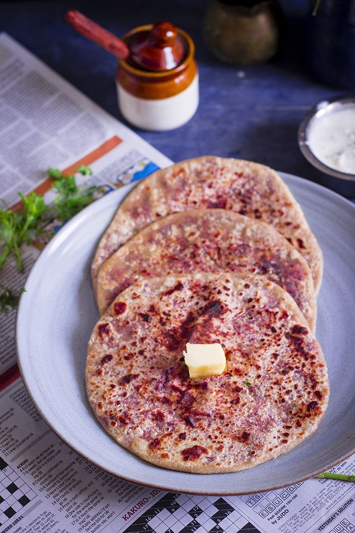 three flat bread pizzas on a plate with butter