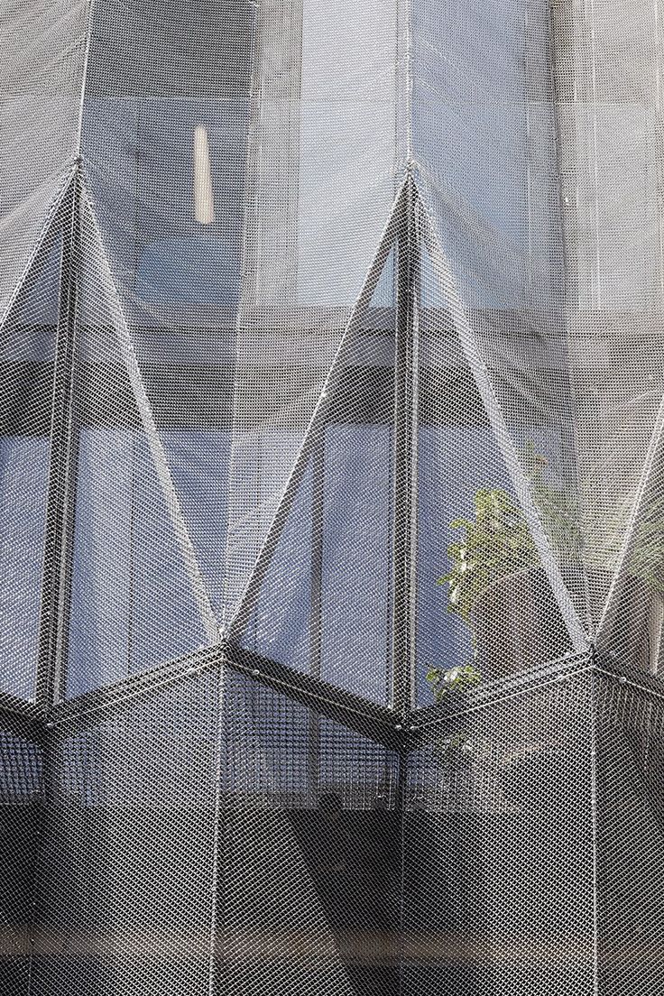 an image of the outside of a building with mesh covering it's walls and windows