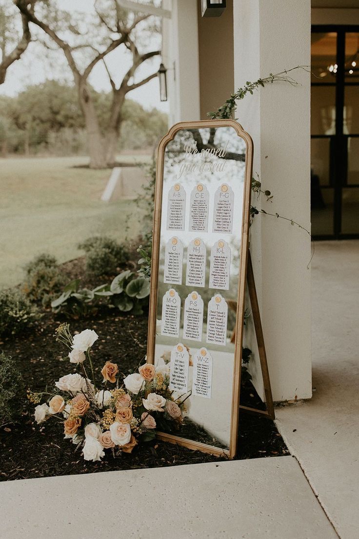 a floral arrangement is placed in front of a mirror on the side of a building