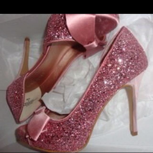 a pair of pink high heels with bows on them