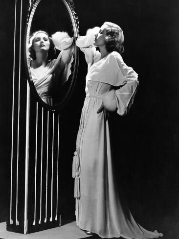 an old fashion photo of two women looking at each other in front of a mirror