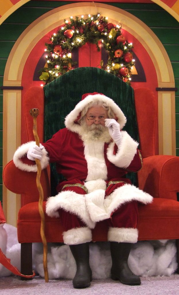 santa claus sitting in a chair with the words 4 ways to avoid going into debt for the holidays