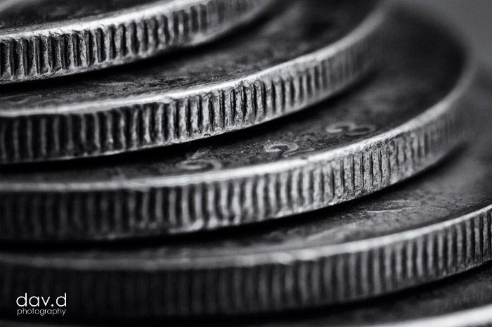 a stack of silver coins sitting on top of each other in black and white photo