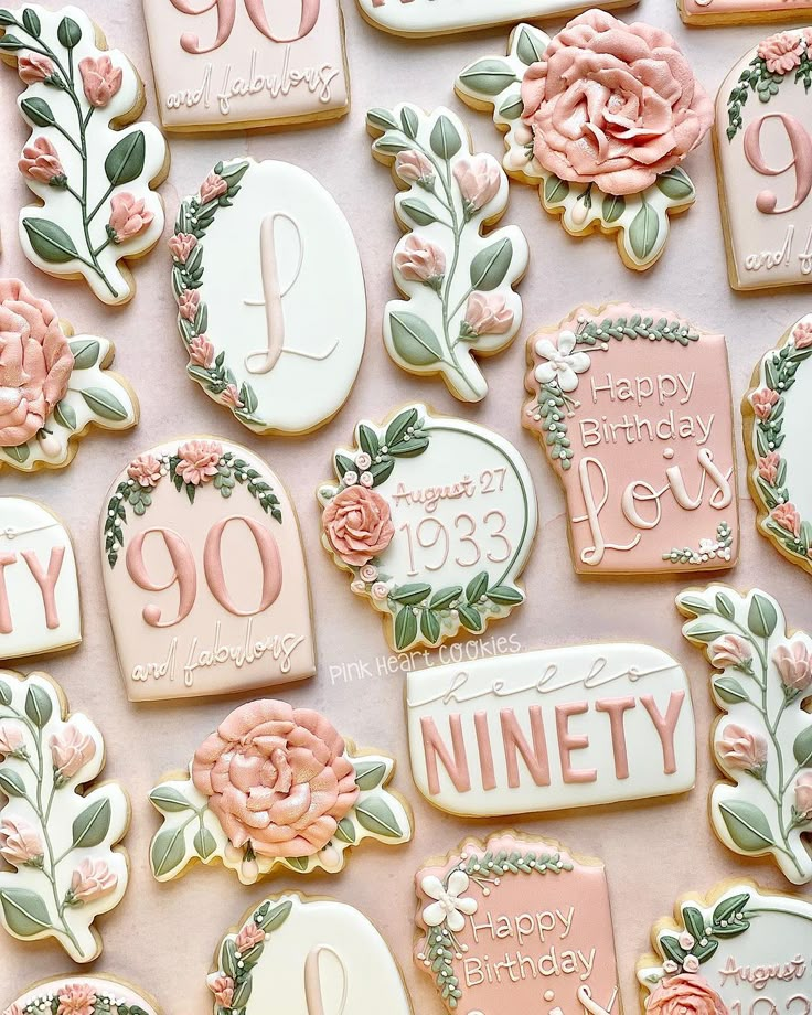 decorated cookies are arranged on a table with pink flowers and the words ninety written in them