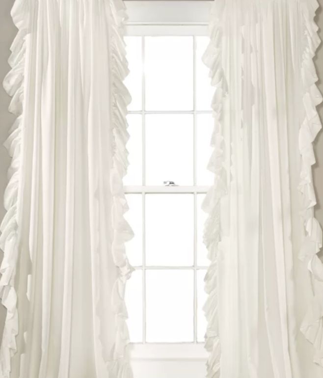 a white curtain with ruffled edges in front of a window