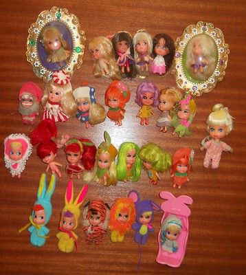 a table topped with lots of little dolls and other small toy figurines on top of a wooden table