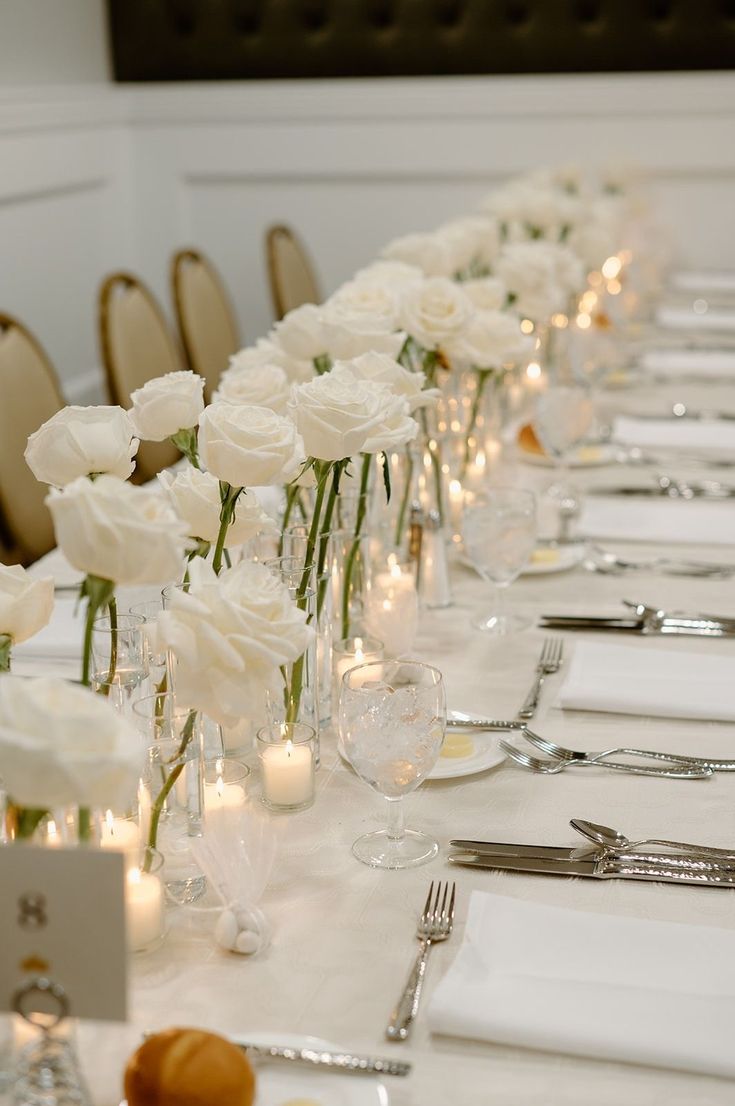 a long table with white flowers and candles