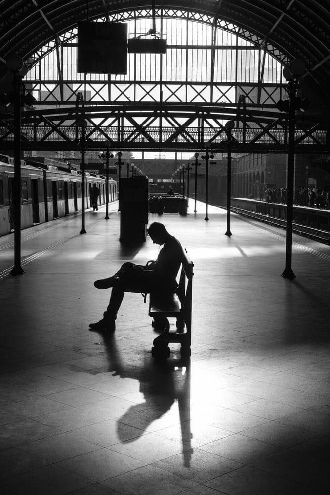 a man sitting on a bench in a train station