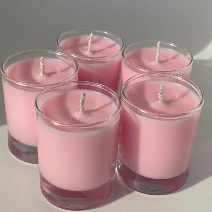 four pink candles sitting next to each other