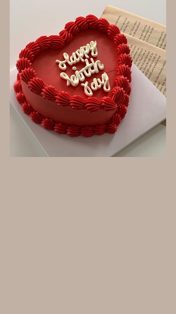 a red heart shaped cake sitting on top of a table