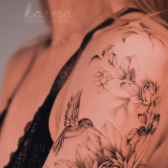 a woman's arm with flowers and a bird on it