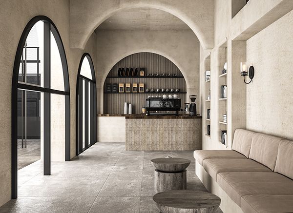 the interior of a restaurant with an arched ceiling and stone flooring, along with large windows