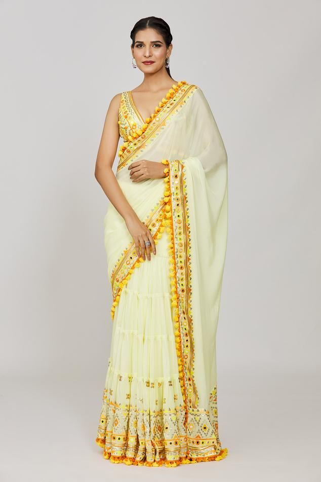 Yellow chiffon pre-draped saree with geometric pattern border, multi layered tiered panels, attached draped pallu, monochrome thread, mirror and sequin embroidery. Paired with embroidered plunged V neck blouse with fringe drop tasselled border.
Components: 2
Pattern: Embroidered and Printed
Type Of Work: Thread, Mirror and Sequin Work
Neckline: Plunged V Neck
Sleeve Type: Sleeveless
Fabric: Saree: Chiffon, Blouse: Tussar Silk
Color: Yellow
Other Details: 
Fringe drop tassel details
Deep V back
B Saree Chiffon, Gopi Vaid, Draped Saree, Drape Saree, Yellow Saree, Sequin Embroidery, Blouse For Women, Sequins Embroidery, Blouse Online