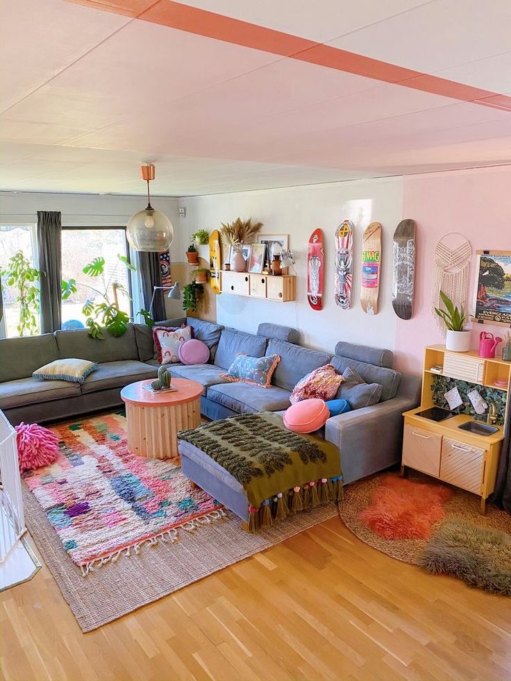 a living room filled with lots of furniture next to a wooden floor covered in rugs