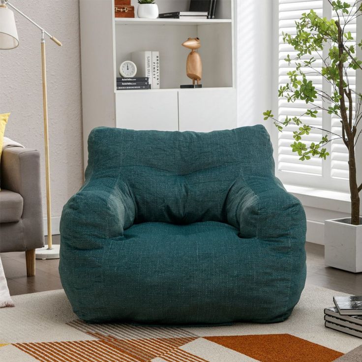 a living room filled with furniture and a green bean bag chair in front of a window