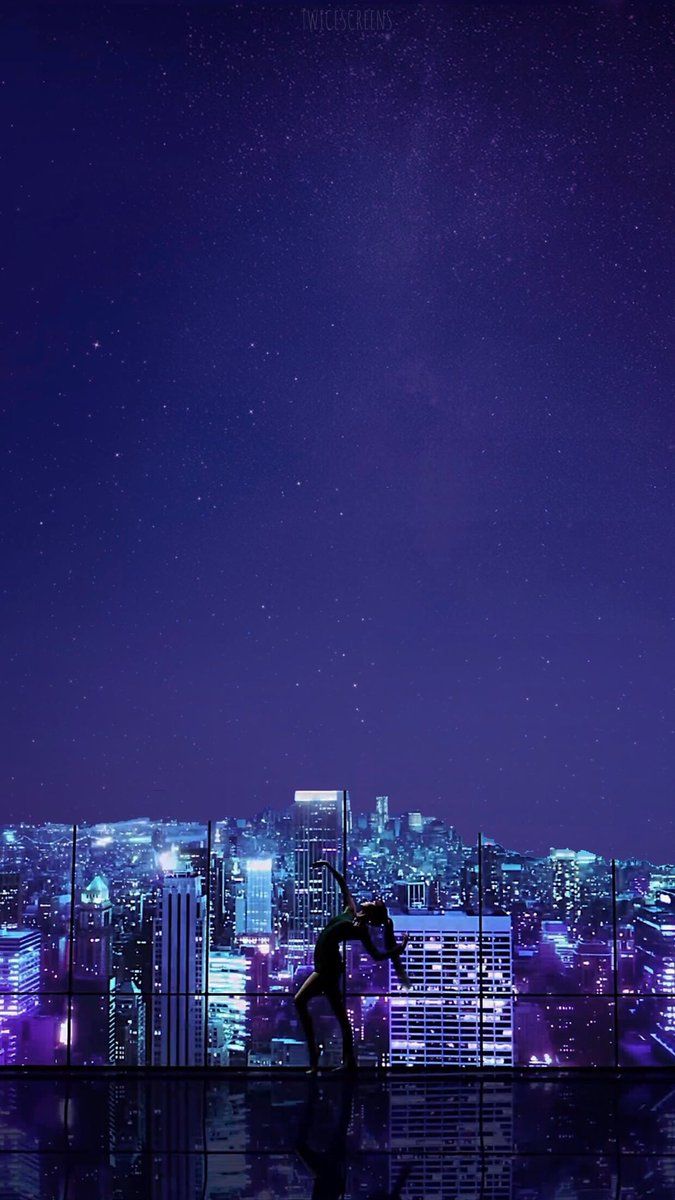 a person standing in front of a cityscape at night