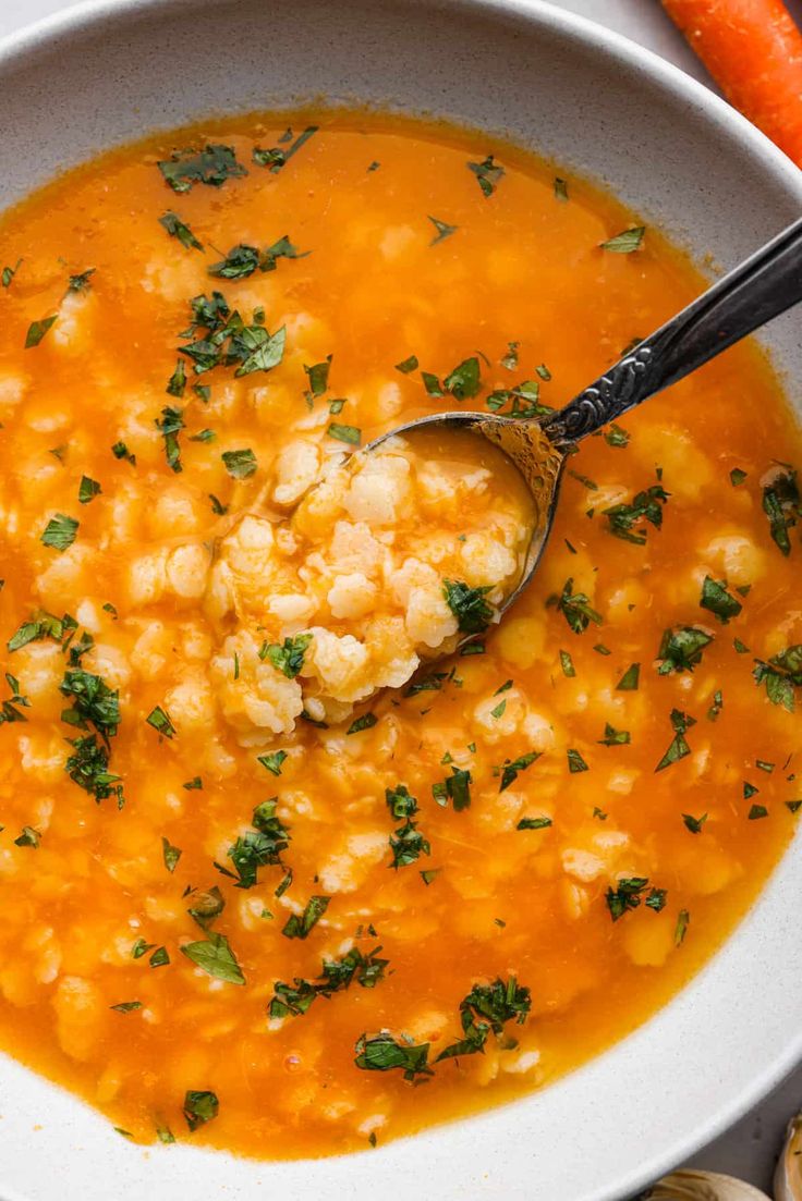 a white bowl filled with carrots and cauliflower