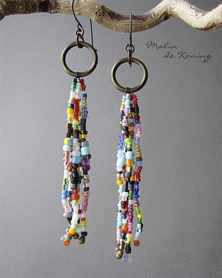 two pairs of earrings hanging from a tree branch with beads on the end of them