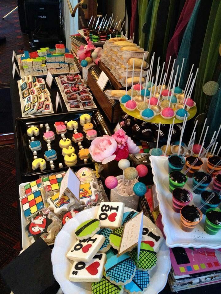 a table filled with lots of colorful desserts and candies on top of plates