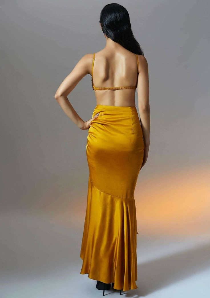 This marigold muse ruched skirt with layered ruffle hem is generously dipped in mustard gold hue. This skirt exudes summer sensuality as the tiers of softly draped satin flow with ease on the body. The playful adjustable drawstring details further accentuate the curves and truly celebrate femininity. Draped Ruched Maxi Skirt For Party, Ruched Draped Maxi Skirt For Party, Yellow Long Skirt For Evening, Party Tiered Draped Skirt With Ruffles, Party Tiered Ruffled Draped Skirt, Elegant Gold Maxi Skirt For Evening, Gold Satin Party Skirt, Silk Ruched Skirt For Party, Gold Fitted Maxi Skirt For Summer