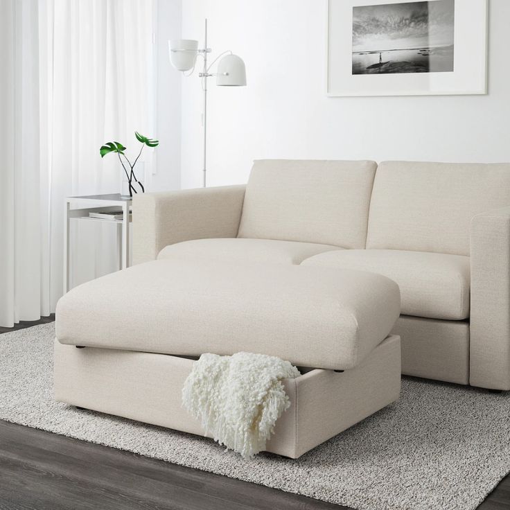 a living room with a white couch and rug on the floor in front of it