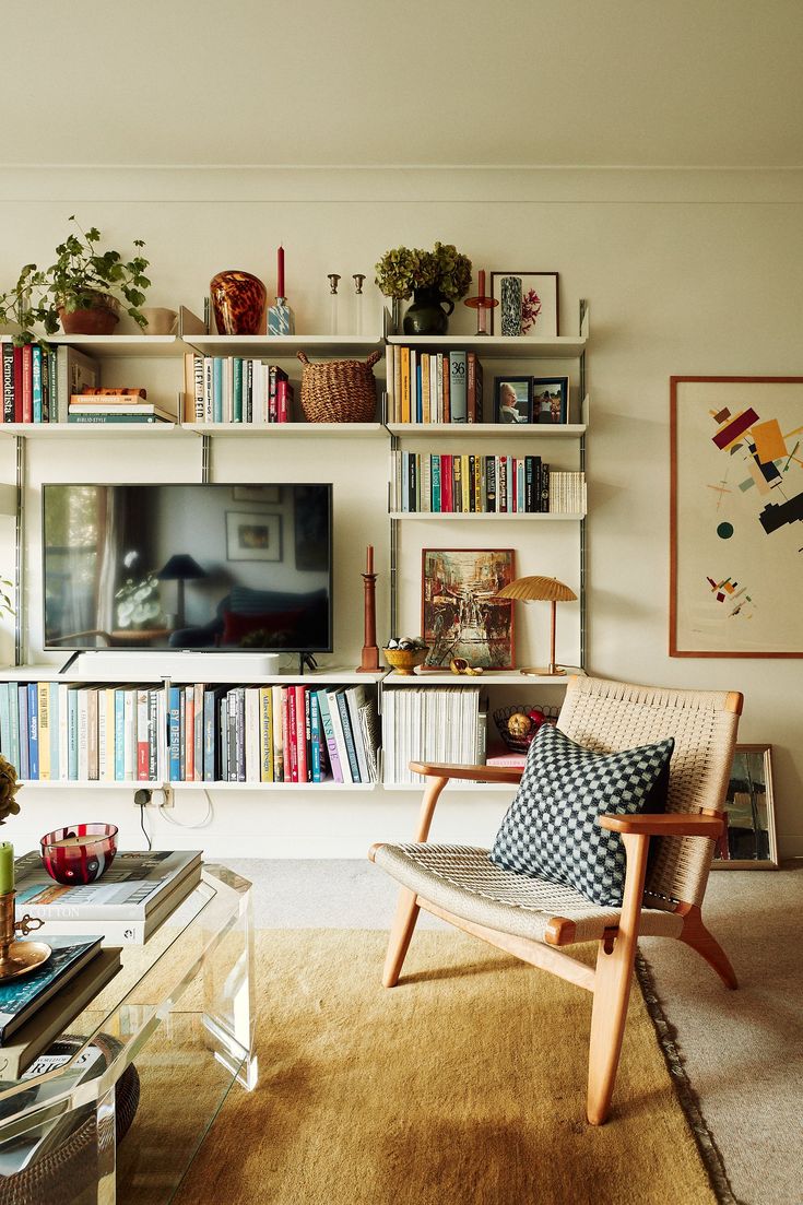 a living room with bookshelves and a television on the wall in front of it