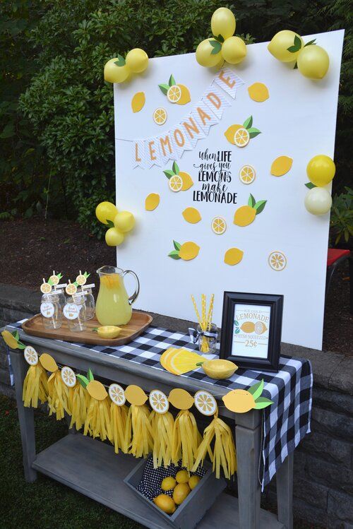 the lemonade bar is set up outside for an outdoor party with lemons on it