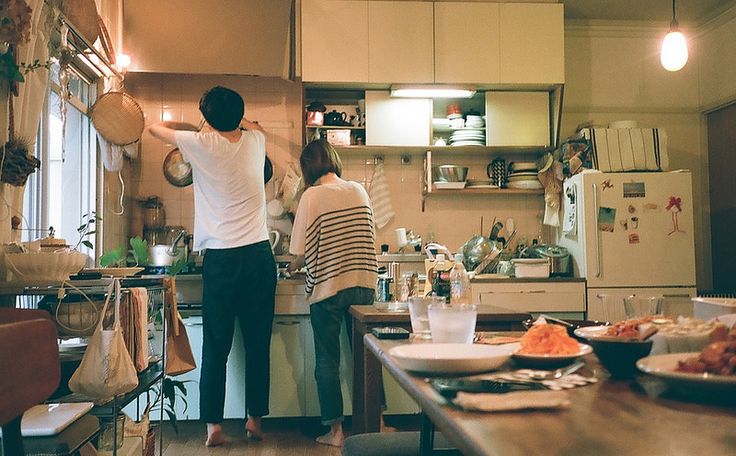 two people standing in a kitchen preparing food