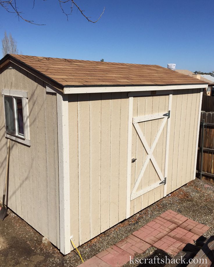 a small shed with a brown roof and windows