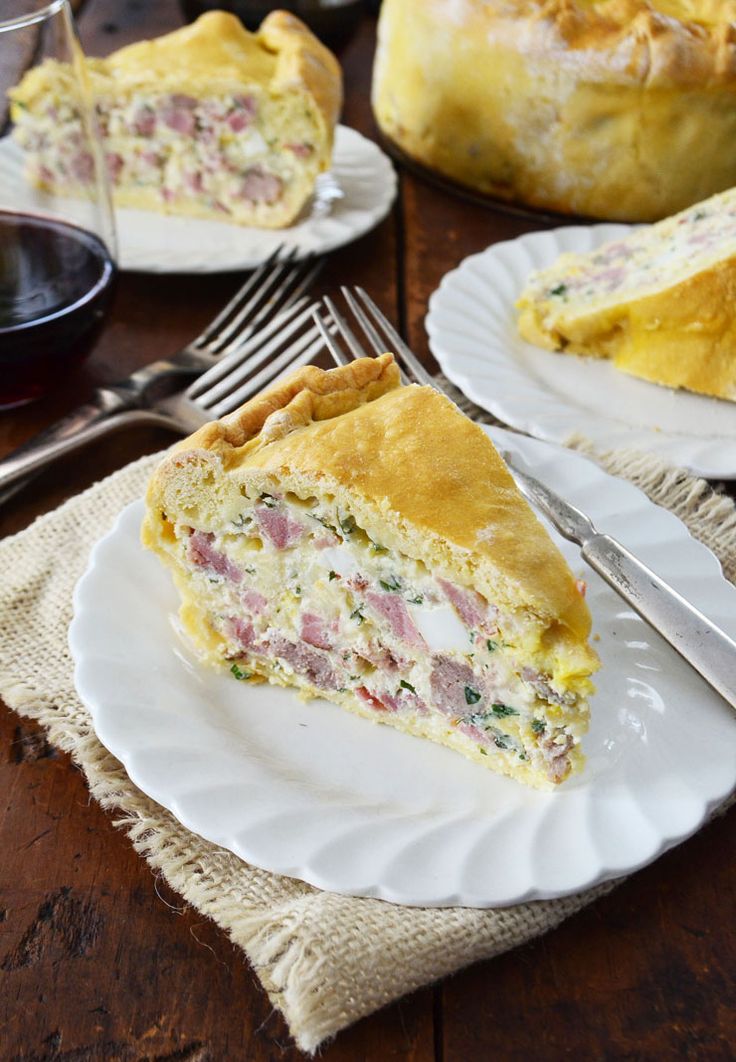 a piece of ham and cheese quiche on a plate with a fork next to it