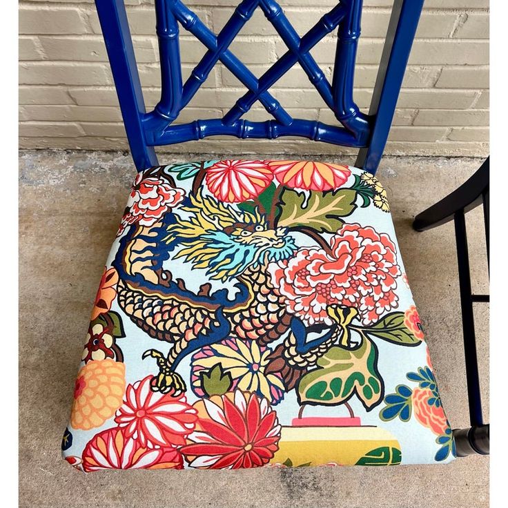 a blue chair with a colorful flowered seat cover on it's backrest