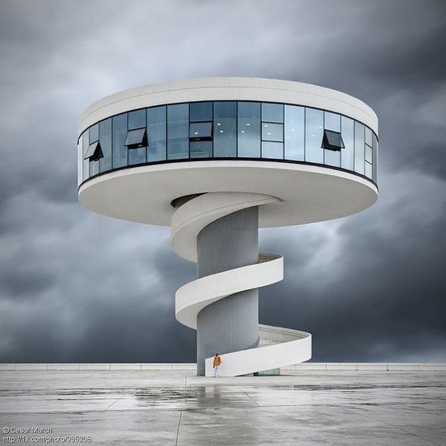 a tall white building sitting under a cloudy sky