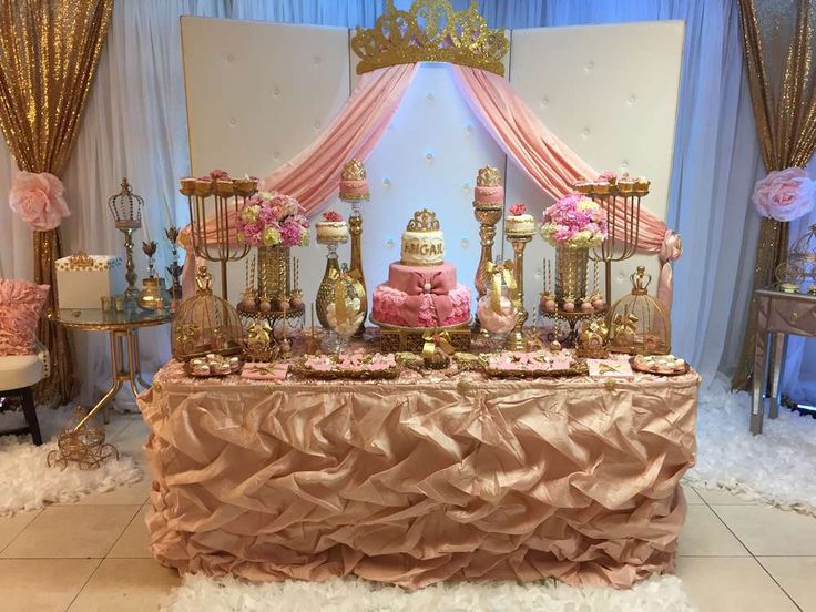 a table topped with lots of pink and gold cakes