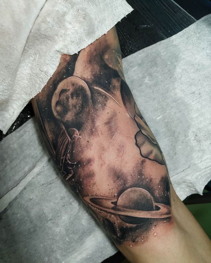 a man's arm with an image of the planets on it