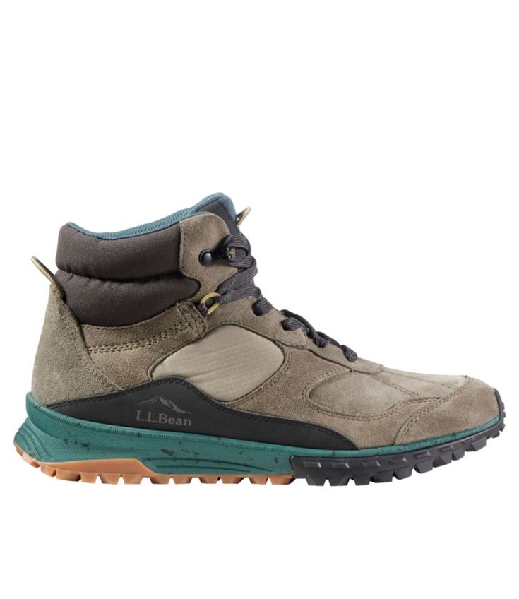 a pair of hiking shoes with green and brown trims on the side, in front of a white background