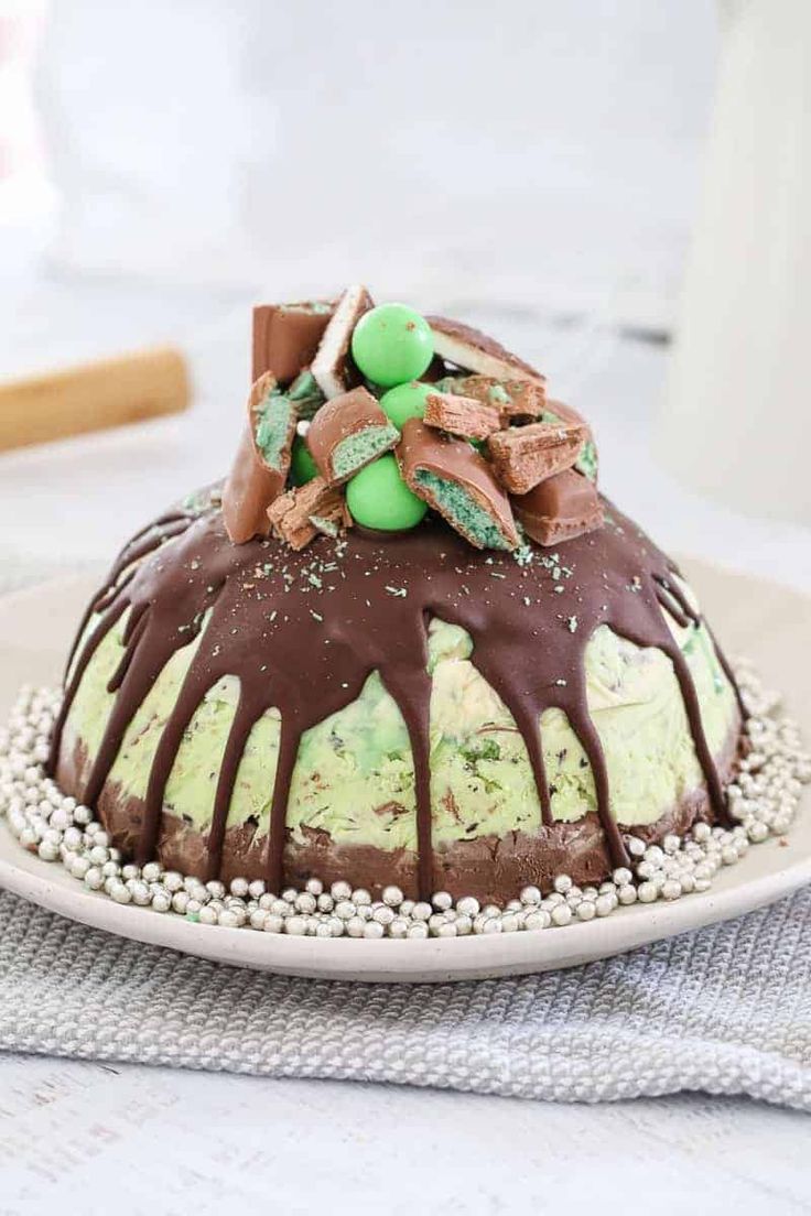 a chocolate cake covered in green and white frosting