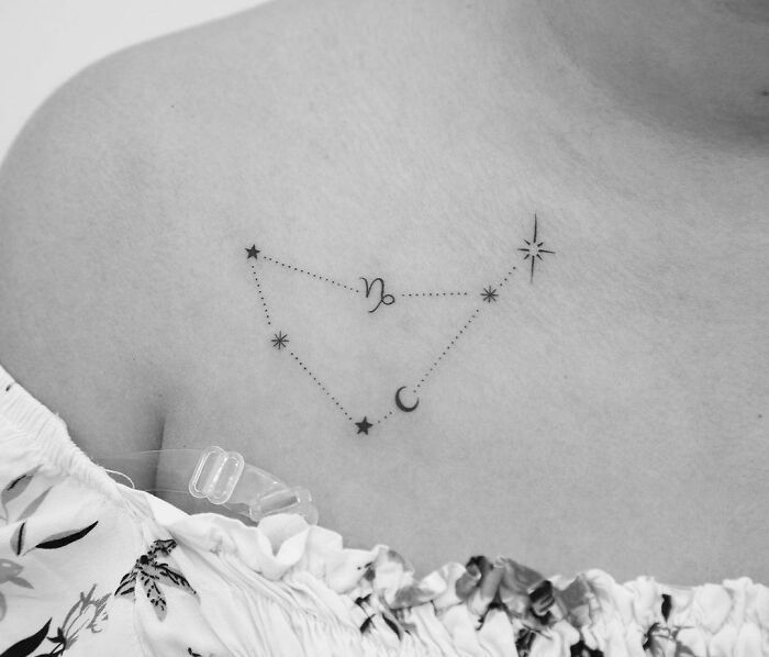 a woman's chest with three stars and the moon on it, all connected together