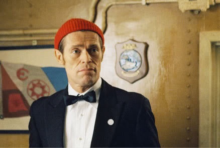 a man in a tuxedo wearing a red knitted hat and bow tie