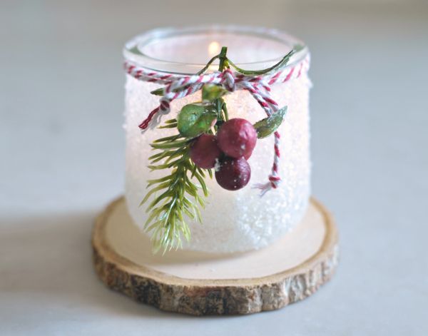 a candle with some fruit on it sitting on a piece of wood in front of a white background