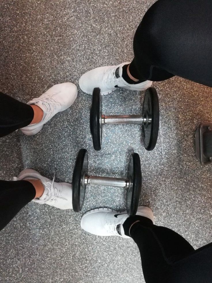 three people standing next to each other with dumbbells on their feet and one person wearing white sneakers