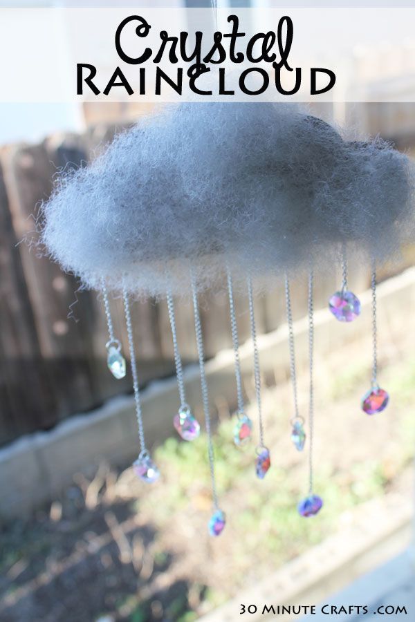 a cloud is hanging from the side of a window with crystal rain drops on it