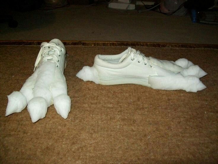 two white shoes that are laying on the floor next to each other, one is covered in foam