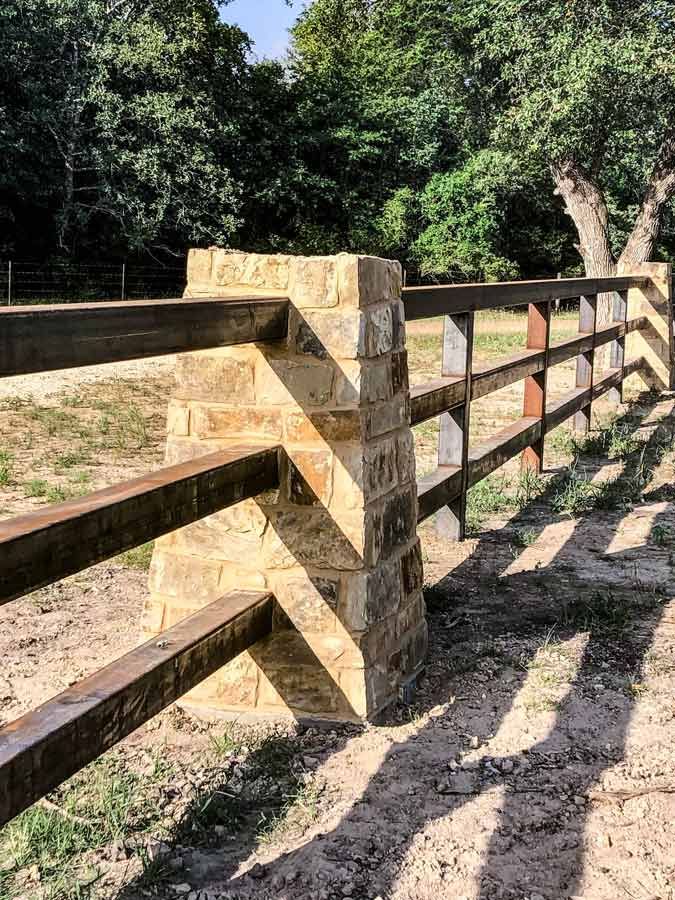 a wooden fence in the middle of a field