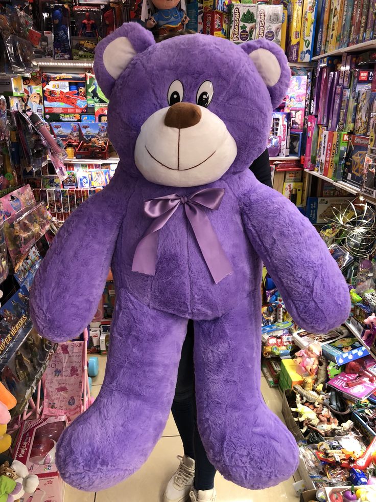 a large purple teddy bear in a store