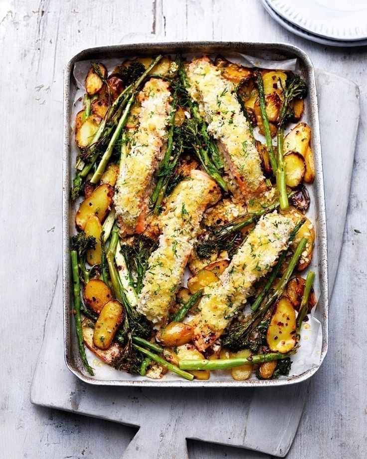 a pan filled with fish, potatoes and asparagus