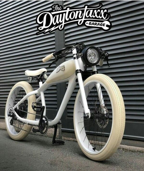 a white and black bike parked next to a building